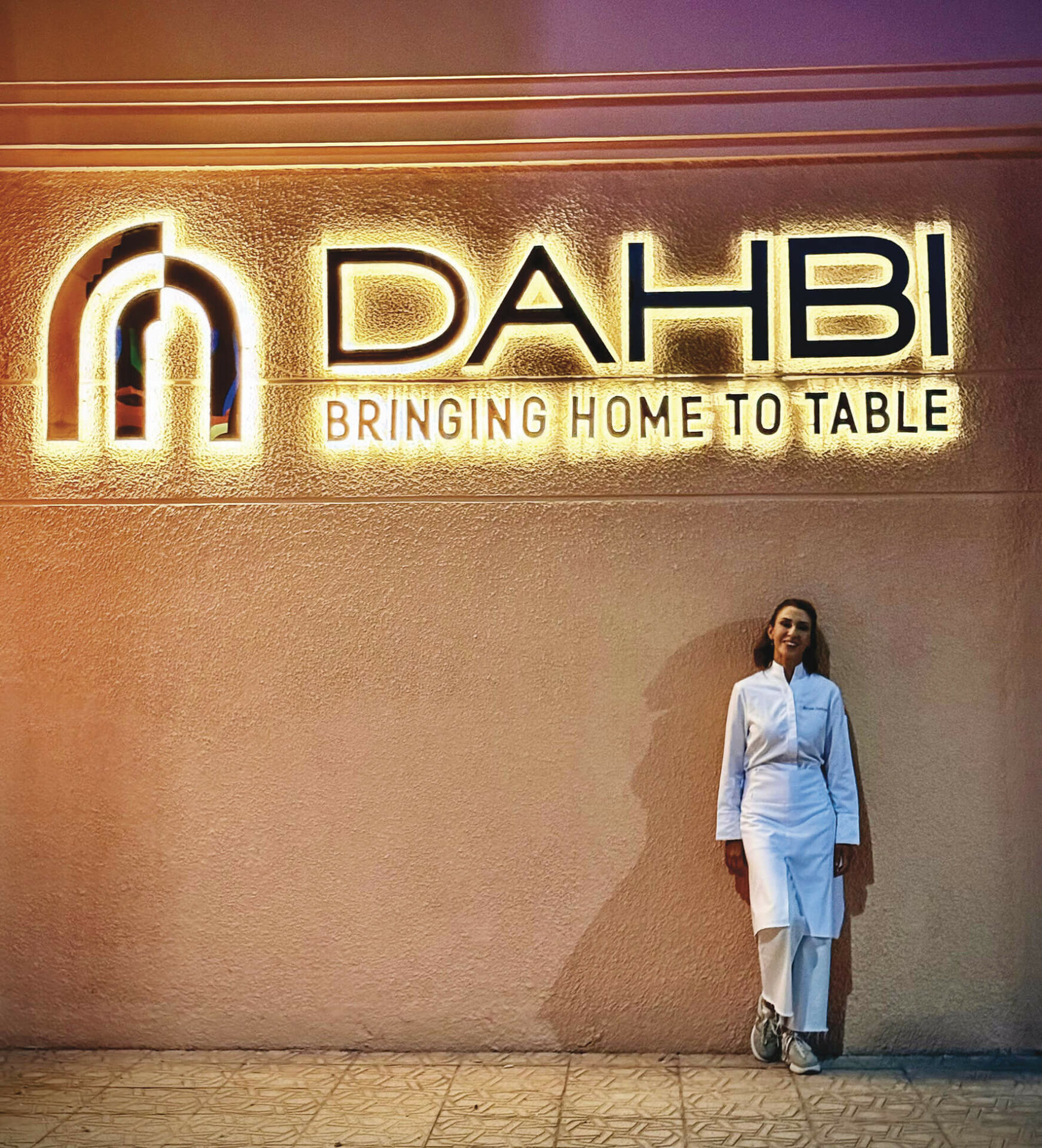 La cheffe Meryem Cherkaoui devant l'enseigne du restaurant Dahbi à Marrakech